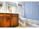 Bathroom with brown wooden vanity and blue shower curtain at 200 S Ocean Blvd. # 3-B, North Myrtle Beach, SC 29582