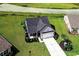 Aerial view of a house and neighborhood with lush green lawns and a pond at 260 Red Maple Loop, Longs, SC 29568