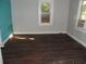 Small bedroom with dark brown flooring, gray walls, and a teal accent wall at 417 S Magnolia Ave., Andrews, SC 29510