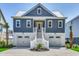 Inviting coastal home with double garage, white trim, and covered entry staircase at 42 Mud Minnow Dr., Pawleys Island, SC 29585