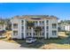 Two-story condo building with balconies, palm trees, and ample parking at 448 Red River Ct. # 39H, Myrtle Beach, SC 29579
