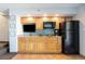 Simple kitchen with light wood cabinets and black appliances at 4800 S Ocean Blvd. # 1007, North Myrtle Beach, SC 29582