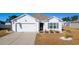 White house with two-car garage and landscaped lawn at 124 Golden Bear Circle, Longs, SC 29568