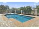 Inviting in-ground pool surrounded by a brick patio, lush greenery, and a secure fence at 1422 Bohicket Ct., Myrtle Beach, SC 29579