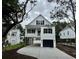 Charming two-story coastal home with black shutters, a covered porch and a driveway leading to a garage at 1718 26Th Ave. N, North Myrtle Beach, SC 29582