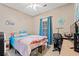 Bright bedroom with a ceiling fan, large window with curtains, desk, and turtle wall decor at 2080 Cross Gate Blvd. # 303, Surfside Beach, SC 29575
