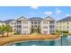 Apartment complex featuring multiple balconies and a picturesque pond with a fountain at 2080 Cross Gate Blvd. # 303, Surfside Beach, SC 29575