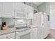 Modern kitchen with white cabinets, stainless steel appliances, and a view to the adjacent dining area at 2080 Cross Gate Blvd. # 303, Surfside Beach, SC 29575