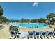 Outdoor community pool with palm trees and lounging areas with tables and umbrellas at 241 Presidential Dr., Surfside Beach, SC 29575