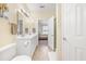 Bathroom with double sinks, white cabinets, and a shower at 257 Connemara Dr. # E, Myrtle Beach, SC 29579