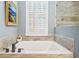 Relaxing bathroom with a soaking tub, white shutters, and elegant tile accents at 265 Venice Way # 1101, Myrtle Beach, SC 29577
