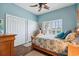 Bedroom featuring blue walls, wood floors, plantation shutters, and white trim at 265 Venice Way # 1101, Myrtle Beach, SC 29577