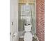 Small bathroom with toilet and brick accent wall at 408 16Th Ave. S, Myrtle Beach, SC 29577