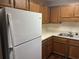 White appliances and wood cabinets in this galley kitchen at 5001 Little River Rd. # E-110, Myrtle Beach, SC 29577