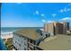 Expansive balcony view featuring the beach, ocean, and a resort building at 501 S Ocean Blvd. # 708, North Myrtle Beach, SC 29582