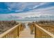 Path to beach with scenic ocean views, dunes, and wood boardwalk, creating a serene and accessible coastal experience at 501 S Ocean Blvd. # 708, North Myrtle Beach, SC 29582