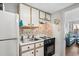 Efficient kitchenette with white cabinetry, black appliances, and floral accents at 501 S Ocean Blvd. # 708, North Myrtle Beach, SC 29582