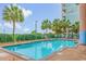 Bright outdoor pool surrounded by tropical landscaping, including palms and greenery, and lounge seating at 501 S Ocean Blvd. # 708, North Myrtle Beach, SC 29582
