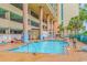 Outdoor pool with lounge chairs, tables, and a view of the building, creating a relaxing vacation environment at 501 S Ocean Blvd. # 708, North Myrtle Beach, SC 29582
