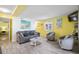 Living area with gray sofas, yellow walls, and coastal decor at 600 S Ocean Blvd. # C-21, North Myrtle Beach, SC 29582