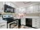 White kitchen with black appliances and a corner sink at 7601 North Ocean Blvd. # 1B, Myrtle Beach, SC 29572