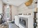 Well-lit laundry room featuring modern washer and dryer, tile floors, and storage shelves at 104 Grace Bay Ct., Pawleys Island, SC 29585