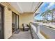 Private balcony with a chair overlooking community amenities, including the pool at 1100 Possum Trot Rd. # E-238, North Myrtle Beach, SC 29582