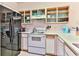 Galley kitchen with white appliances and open shelving at 1302 River Oaks Dr. # 4-F, Myrtle Beach, SC 29579