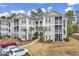 Inviting condo building with multiple stories, manicured landscaping, and ample parking at 242 Sun Colony Blvd. # 303, Longs, SC 29568
