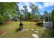 Beautiful backyard with a smoker, stone walkway, lush landscaping, shed, and steps to back door at 40 Capt Anthony White Ln., Georgetown, SC 29440