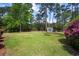 Expansive backyard featuring a well-maintained lawn and a charming storage shed surrounded by mature trees at 40 Capt Anthony White Ln., Georgetown, SC 29440