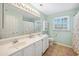 Bright bathroom with a double vanity, large mirror, tiled floor, and a combined shower and tub at 40 Capt Anthony White Ln., Georgetown, SC 29440