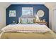 Inviting bedroom features a blue accent wall, plush throw blanket, and natural light from the window at 40 Capt Anthony White Ln., Georgetown, SC 29440