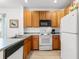 Galley style kitchen featuring wood cabinets and white appliances at 4533 Girvan Dr. # D, Myrtle Beach, SC 29579