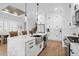 Bright kitchen featuring a large island, white cabinets, and hardwood floors at 6760 Ocean Breeze Loop, Myrtle Beach, SC 29572