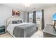 Bedroom with a gray color scheme, a bed, a nightstand, and two windows offering a view of the neighborhood at 688 Tattlesbury Dr., Conway, SC 29526
