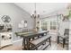 Dining area with wooden table, chandelier, coffee bar, and natural light from two windows at 688 Tattlesbury Dr., Conway, SC 29526