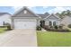 Charming single-story home features a well-manicured lawn and attached two-car garage at 688 Tattlesbury Dr., Conway, SC 29526