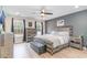 Main bedroom with wood-look floors, a ceiling fan, dresser, and windows overlooking the backyard at 688 Tattlesbury Dr., Conway, SC 29526