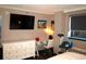Bright bedroom features a desk, dresser, and large TV at 6900 N Ocean Blvd. # 111, Myrtle Beach, SC 29572