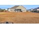 House and backyard with dormant grass at 134 Vineyard Lake Circle, Conway, SC 29527