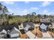 A high aerial shot presents a single story home, driveway, lawn, mature trees, and a fenced backyard at 160 Maggie Way, Myrtle Beach, SC 29588