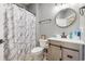 Cozy bathroom with a round mirror, modern vanity, and marble-patterned shower curtain at 160 Maggie Way, Myrtle Beach, SC 29588