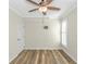 Simple bedroom with hardwood floors, shuttered windows, ceiling fan, and white door at 1609 Harbor Dr., North Myrtle Beach, SC 29582