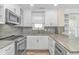 Well-lit kitchen offers stainless steel appliances, granite counters, and custom white cabinetry at 1609 Harbor Dr., North Myrtle Beach, SC 29582