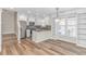 Stylish kitchen with white cabinets, stainless steel appliances, and hardwood floors, leading to the stairway at 1609 Harbor Dr., North Myrtle Beach, SC 29582