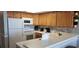 Kitchen with wood cabinets, white countertops and appliances at 2406 N Ocean Blvd. # Ph4-1704, Myrtle Beach, SC 29577