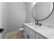 Stylish powder room with a round mirror, modern black faucet, and quartz countertop on the vanity at 3220 Highway 19, Conway, SC 29526