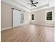 Sunlit bedroom with a sliding barn door leading to the bathroom and a tray ceiling with ceiling fan at 3220 Highway 19, Conway, SC 29526