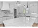 Bright, open kitchen featuring a large island with a marble countertop, stainless sink, and modern lighting at 3220 Highway 19, Conway, SC 29526
